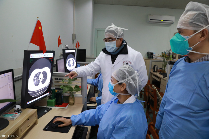 Egészségügyi dolgozók nézik egy beteg CT képét a vuhani Zhongnan kórházban 2020. február 2-án