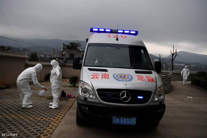 Egészségügyi dolgozók, akik a koronavírusos vagy koronavírus-gyanús embereket szállítják, fertőtlenítik egymást Kunmingban 2020. február 9-én