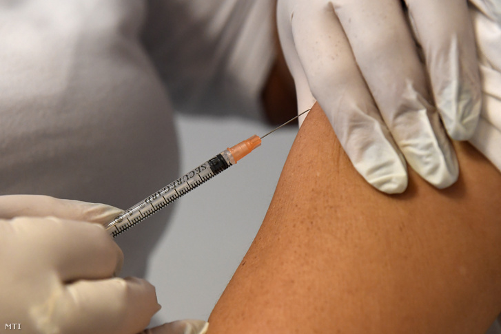 Influenza elleni védőoltást ad be egy egészségügyi dolgozó egy orvosi rendelőben