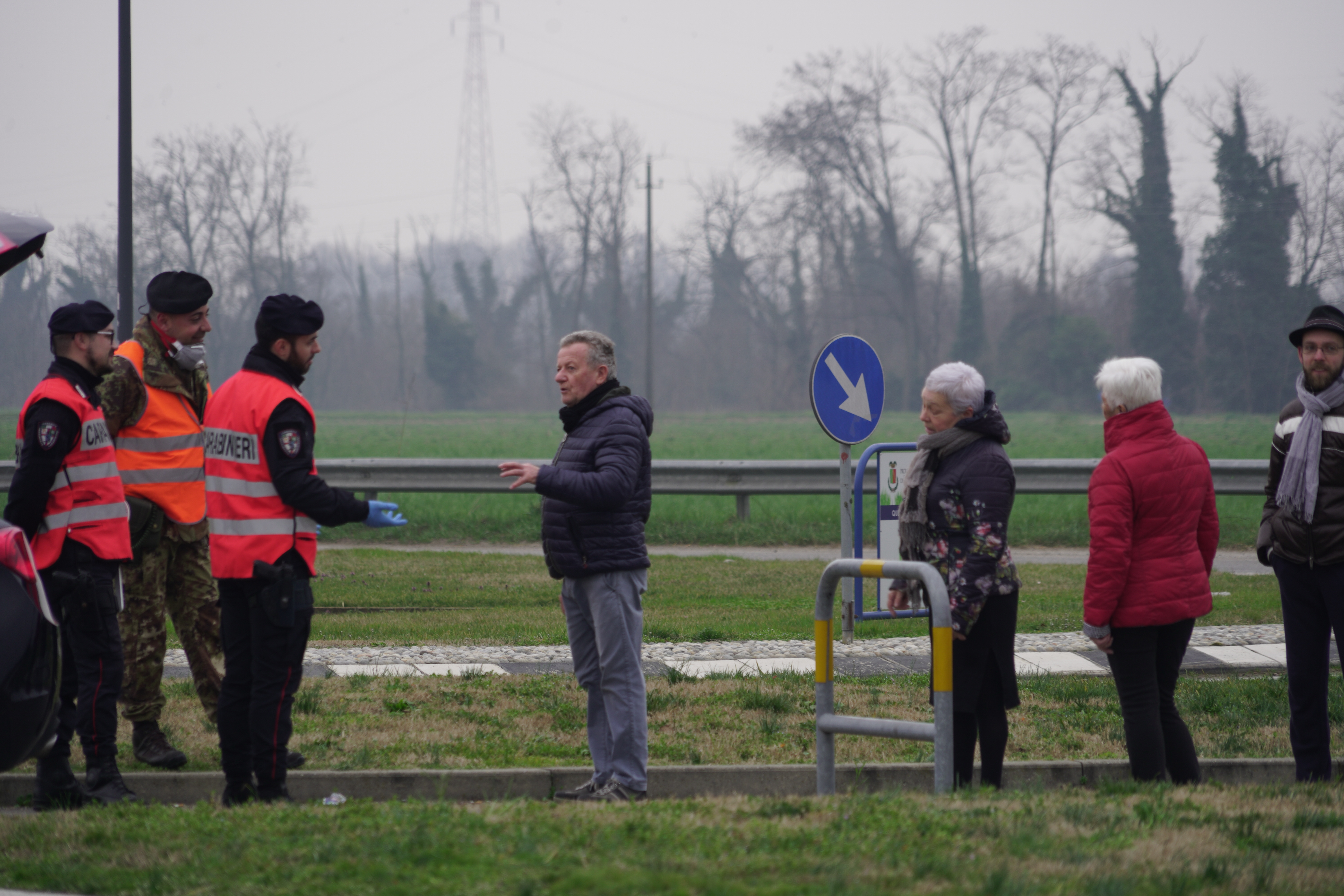 A koronavírus miatt karanténba zárt lakosok beszélgetnek a karantént őrző katonákkal Olaszországban az SP26-os úton felállított ellenőrző pontnál, Turano Lodigiano és Castiglione d'Adda között, 2020. február 25-én.