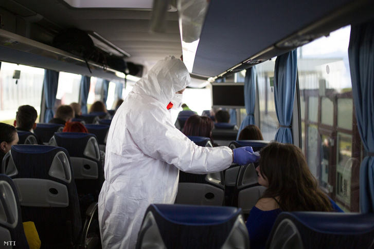 Mentőápoló ellenőrzi egy érkező busz utasait a koronavírus-járvány miatt a letenyei határállomáson 2020. február 5-én