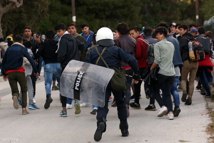 Illegális bevándorlók és görög rohamrendőrök a mitílíni kikötőben miután a helybeliek megakadályozták a migránsok bejutását a móriai befogadótáborba 2020. március 3-án.