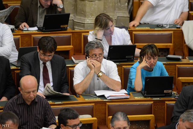Lasztovicza Jenő a Fidesz képviselője (k) telefonál az Országgyűlés plenáris ülésén. Mellette Horváth Zsolt és Talabér Márta olvas előtérben balra Nógrádi Zoltán