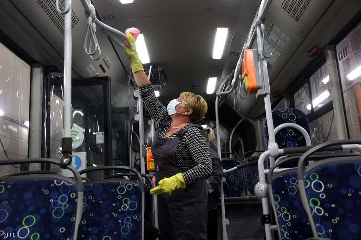Kapaszkodót fertőtlenítőszerrel tisztít egy autóbuszon a Miskolci Közlekedési Vállalat munkatársa a koronavírus terjedésének megelõzése érdekében