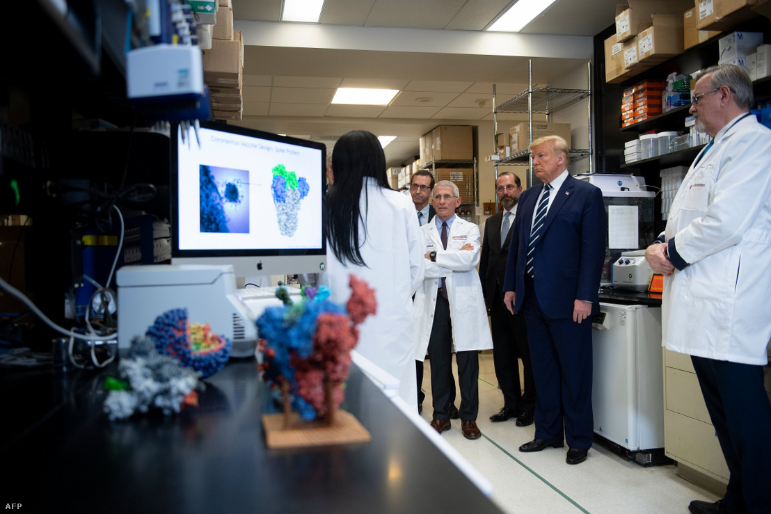 Donald Trump amerikai elnök és Tony Fauci a nemzeti allergia- és járványügyi hivatal vezetője tesznek látogatást a Nemzeti Egészségügyi Intézetek Központjában 2020. március 3-án. Március 16-én az intézmény közleményben adta ki, hogy megkezdték az új típusú koronavírus ellen kifejlesztett első vakcina tesztelését.