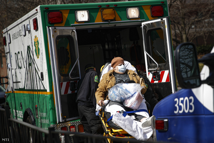 Védőmaszkos beteget tesznek mentőautóba a New York-i Brooklyn Kórházközpontnál 2020. március 18-án