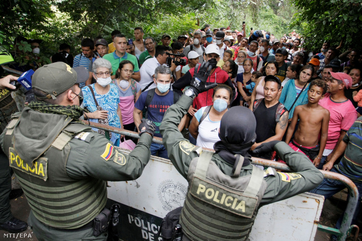 Kolumbiai rendőrök eligazítják a hazatérni kívánó venezuelai állampolgárokat a venezuelai határnál fekvő kolumbiai Cúcutában 2020. március 15-én. A két ország közötti határt zárva tartják az új koronavírus járványa miatt de a Kolumbiában élő venezuelaikat humanitárius okokból hazaengedik.