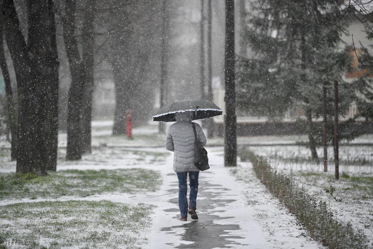 Járókelő a hóesésben Debrecenben 2020. március 23-án
