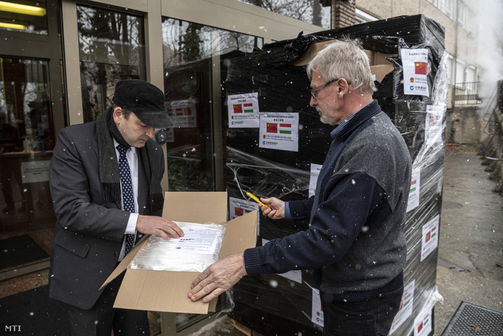 Horpácsy Balázs az Állami Egészségügyi Ellátó Központ főigazgató-helyettese és munkatársa kinyit egy dobozt a China Construction Bank adományából amely Párizsból érkezett a központba 2020. március 23-án.