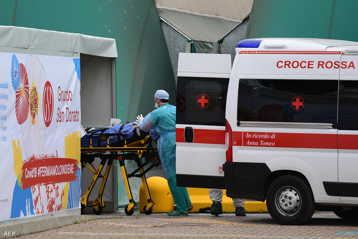 Egészségügyi dolgozók fogadnak egy koronavírussal fertőzött beteget a milánói San Raffaele kórház melletti sportközpontban létrehozott intenzív osztályon 2020. március 23-án.
