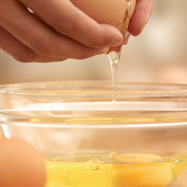 Пить сырые яйца натощак. Сырой яичный белок. Желток в руке.
