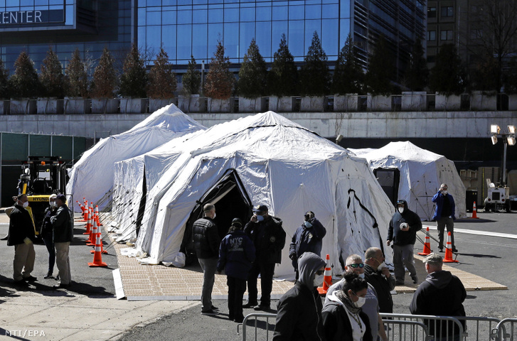 Ideiglenes halottasházként funkcionáló sátrakat állítanak fel munkások a New York-i Bellevue kórház mellett 2020. március 26-án