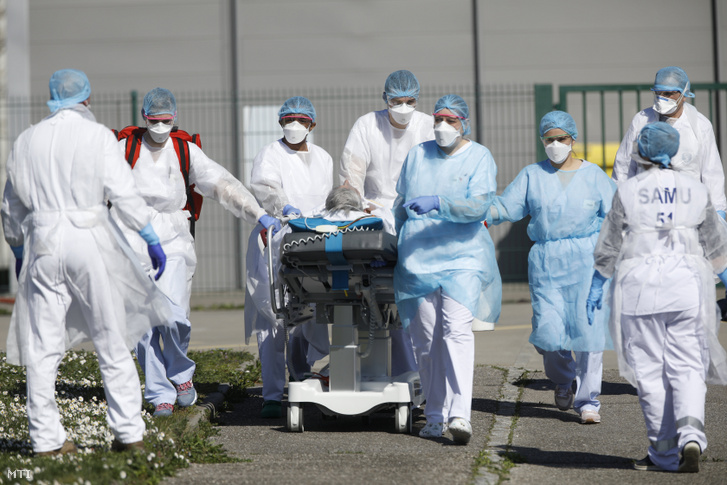 A fertőzött betegek egyikét szállítják el ápolók a kelet-franciaországi Mulhouse város kórházából 2020. március 23-án.