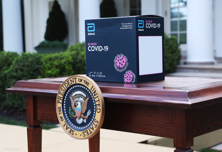 Az Abbott orvostechnikai eszközöket gyártó cég ID Now nevű gyorstesztet végző készüléke egy asztalon a koronavírus-járvánnyal kapcsolatos intézkedéseket irányító kormányzati munkacsoport sajtókonferenciáján a washingtoni Fehér Ház rózsakertjében 2020. március 30-án.