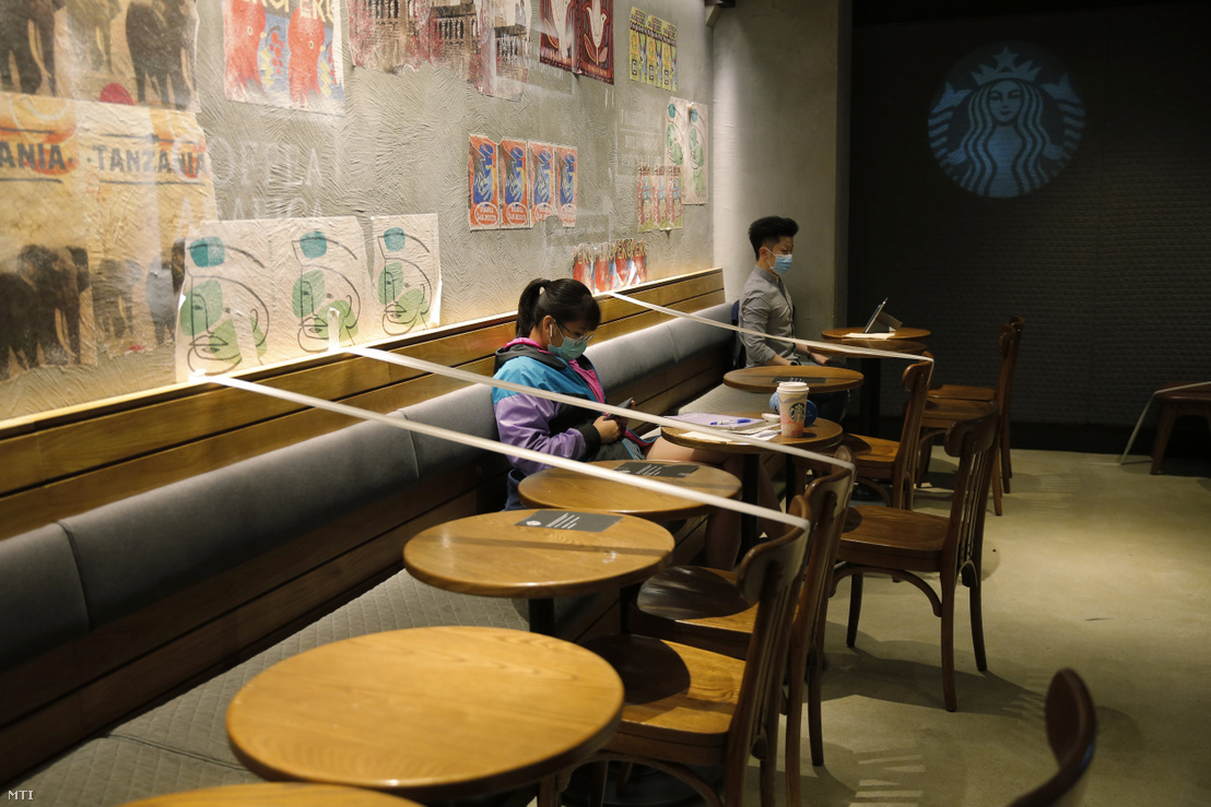 A vendégek közötti biztonságos távolságra figyelmeztető csíkok egy hongkongi kávézóban 2020. március 29-én.