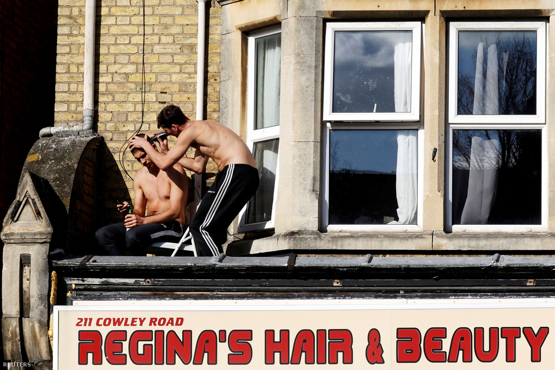 Fiatal srác vágja a barátja haját egy, a koronavírus-járvány miatt bezárt fodrászat feletti tetőn az angliai Oxfordban, 2020. március 31-én