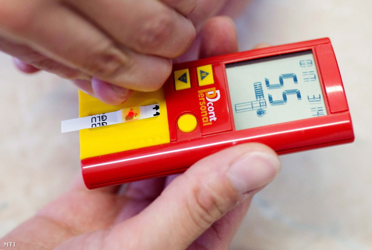 Egy háziorvos egy beteg ujjbegyéből vérmintát cseppent egy vércukorszintmérő műszer érzékelőjére egy budapesti rendelőben.