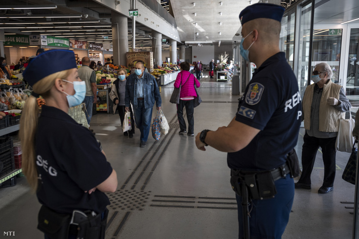 Rendőrök az Újpesti Piac és Vásárcsarnokban, 2020. április 11-én. A járvány miatt az önkormányzat kötelezővé tette a vásárcsarnok területén a védőmaszk, illetve annak funkcióját betöltő, orrot és arcot takaró kendő vagy sál használatát.