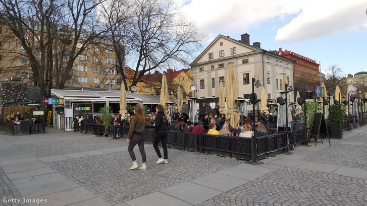 A kellemes időt élvező stockholmiak egy zsúfolásig telt étterem teraszán, április 4-én