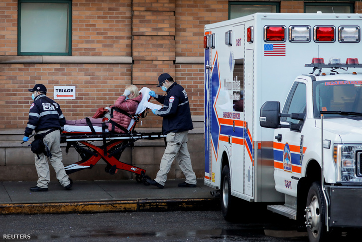 Mentősök szállítanak beteget a Brooklyn-i Maimonides Egészségügyi Központ sürgősségi részlegébe 2020. április 13-án