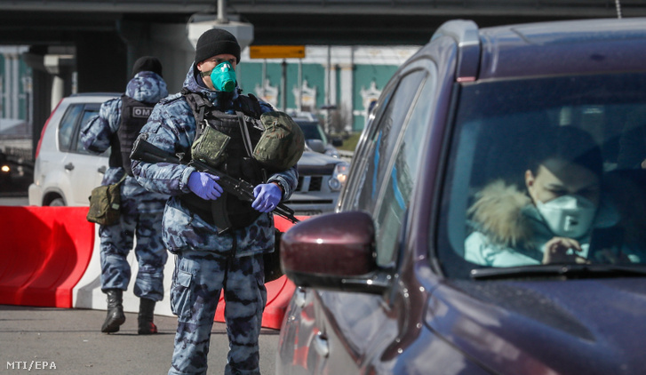 Rendőrök ellenőrzik az autóban ülő embereket egy ellenőrzési pontnál a Moszkvába vezető autópályán 2020. április 15-én.
