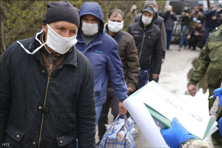A koronavírus-járvány miatt védõmaszkot viselő Donyec-medencei szakadárok a fogolycsere során a kelet-ukrajnai frontvonal mentén 2020. április 16-án.