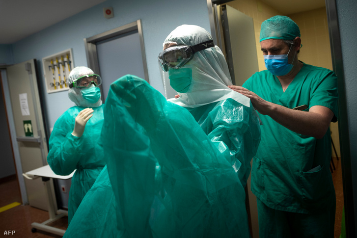 Egészségügyi dolgozó öltözik be, mielőtt bemenne a koronavírussal fertőzött betegek intenzív osztályára a spanyolországi Vigóban 2020. április 16-án