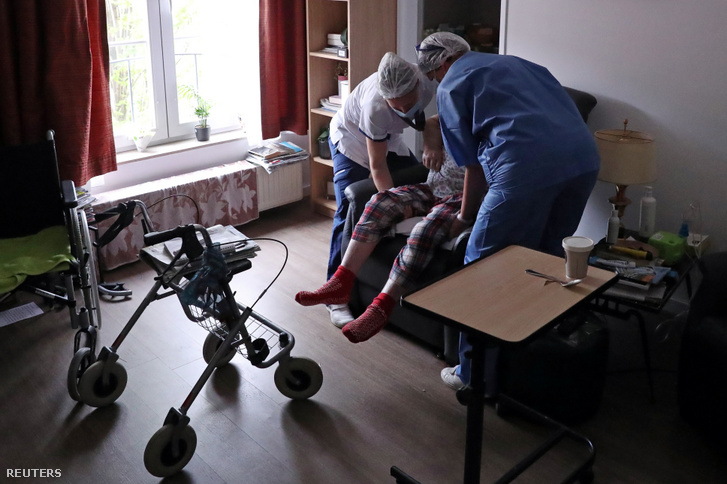 Gondozók segítenek Brüsszel (Belgium) Jette régiójában lévő Christalain Idősek Otthona egyik lakójának 2020. április 13-án