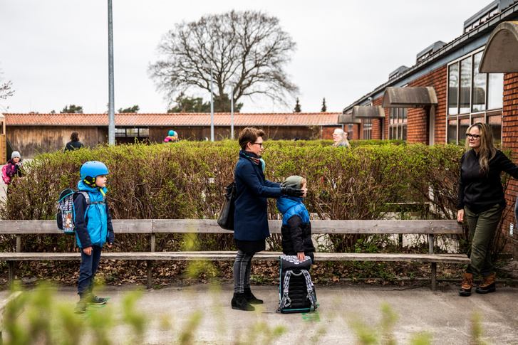 Szülők és gyerekeik várakoznak sorban állva a Sttengaard iskola előtt 2020. április 15-én Koppenhágában. Egy hónap után részlegesen újraindult a tanítás Dániában.
