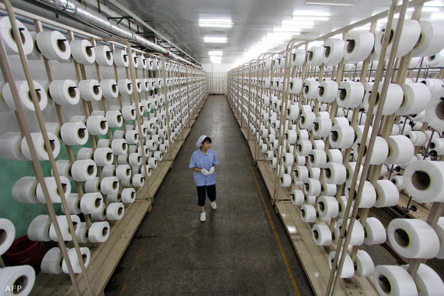 Óriás szövőgépet ellenőriz egy munkás Fucsien tartomány egyik textilgyárában