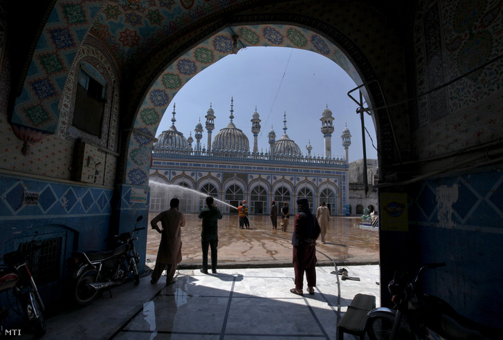 Fertőtlenítik egy ravalpindi mecset udvarát 2020. április 21-én