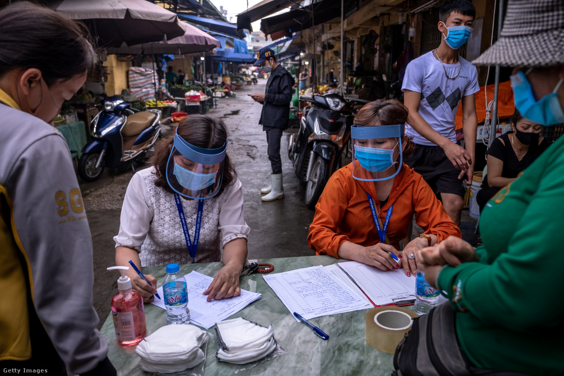 Hanoi piacon gyűjtik az ott dolgozók koronavírusra vonatkozó tesztadatait 2020. április 18-án. Városszerte biztosítottak gyorsteszteket a vírus terjedésének megállítása érdekében.