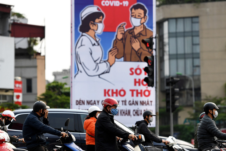 Az április 23-án enyhített korlátozások után a fővárosi forgalomban szájmaszkot viselők mögött a kormányzat plakátja látható.