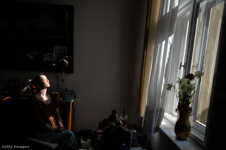 Krakkói otthonában élvezi a napsütést egy nő a koronavírus-járvány és lezárás idején 2020. április 1-én