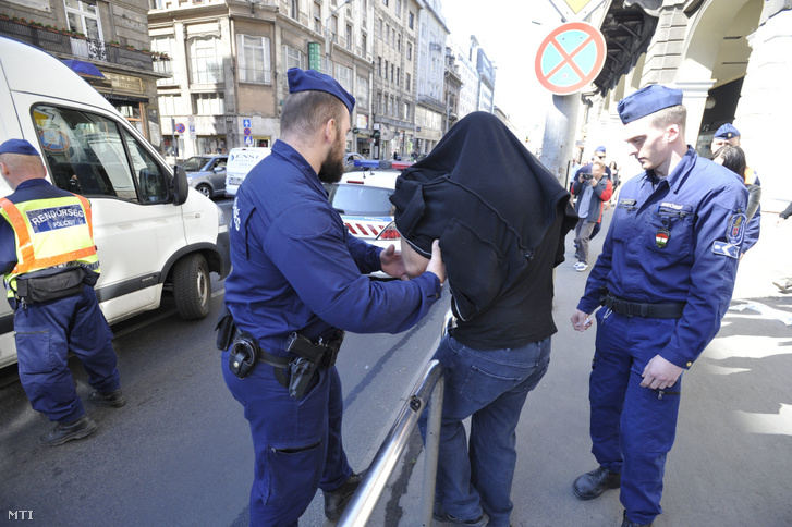 Rendőrök elvezetnek egy férfit egy budapesti szórakozóhelyről ahol razziát tartottak 2019. április 19-én.