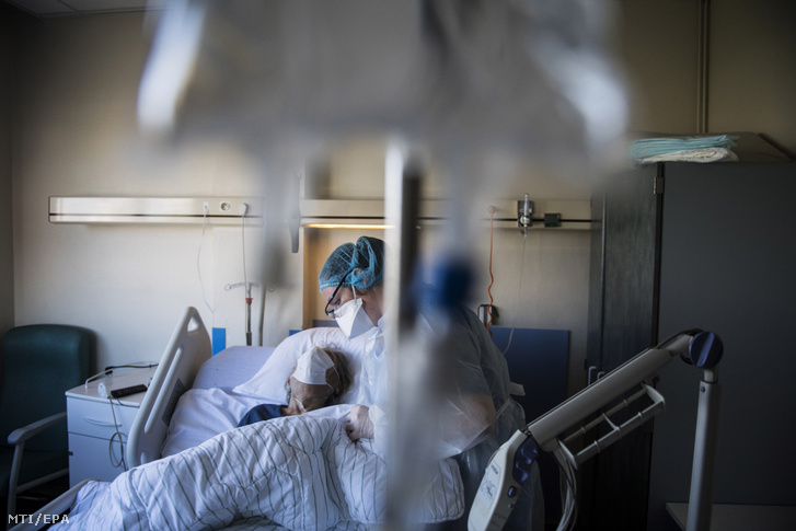 Koronavírussal fertőzött beteget ápol egy védőruhás nővér egy Párizs melletti klinikán 2020. április 22-én.