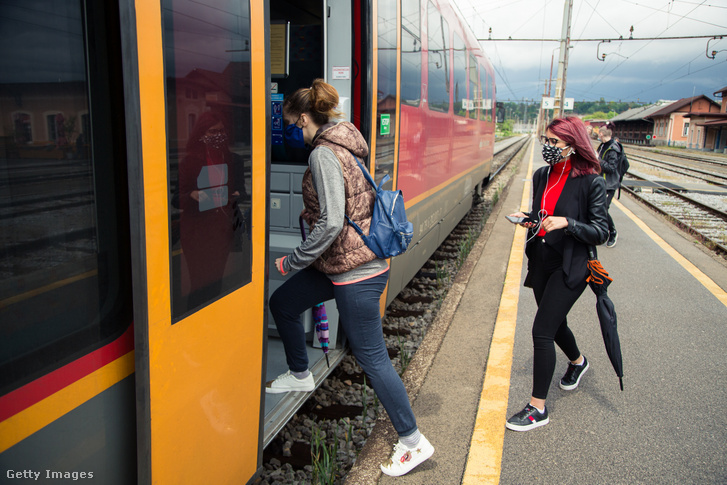 Maszkot viselő utasok szállnak fel egy vonatra Szlovéniában 2020. május 11-én