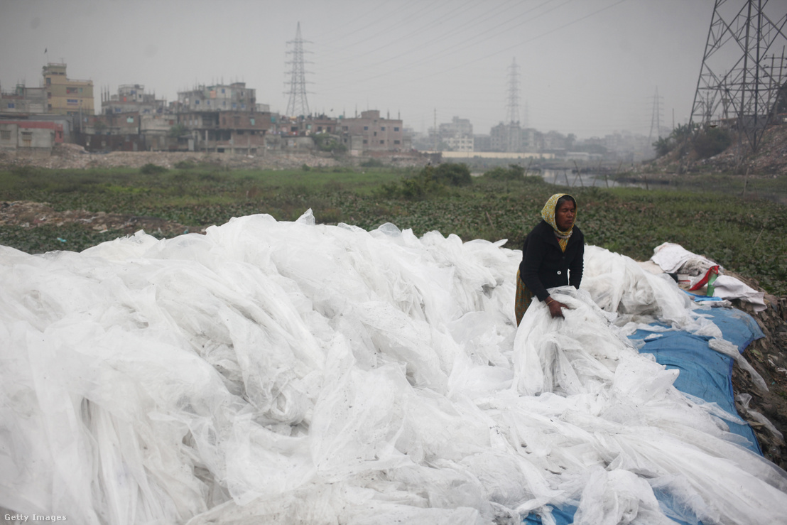 Egy nő vegyi anyagok szállítására használt műanyag zacskókat gyűjt Bangladesben a Buriganga folyó mellett 2020. január 9-én.