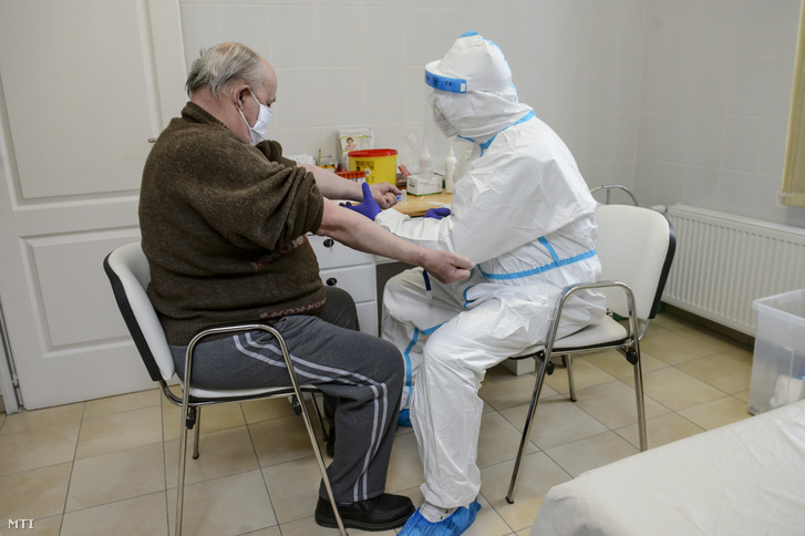 Vért készül venni egy férfi karjából a koronavírusteszthez a Debreceni Egyetem szakembere az intézmény egyik mintavételi pontján a rózsaszentmártoni Kövirózsa Egészségházban 2020. május 13-án.