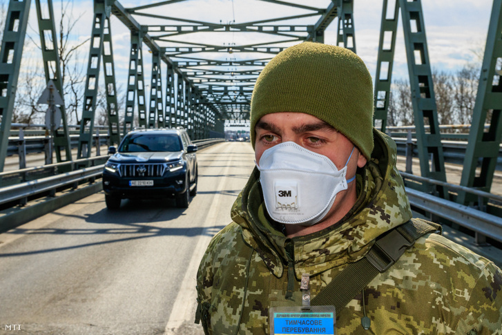 Védőmaszkot viselő ukrán határőr a Csaphoz közeli Tisza közúti határátkelőn az ukrán-magyar határon 2020. február 25-én