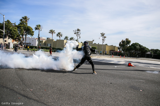 Egy kaliforniai tüntető próbálja visszahajítani a rendőrökre a könnygázgránátot