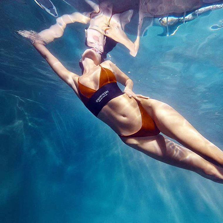 Újabb színes fotó következik, amin nem elég, hogy a modell úszik éppen, de még arról sem feledkezik meg, hogy érzékien megérintse a csípőjét.