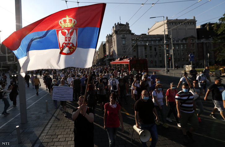 Szerb zászlót lengető tüntetők vonulnak a parlament elé Belgrádban 2020. július 8-án