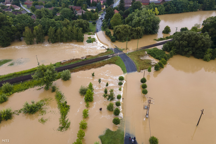 A nagy esõzés miatt vízzel elárasztott és megrongálódott út Zalaszentjakabon 2020. július 25-én. Középen a Budapest-Nagykanizsa vasútvonal része látható.