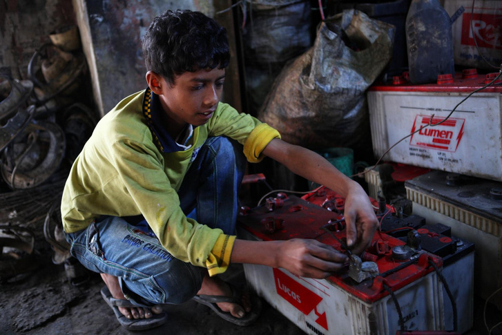 Bangaldeshi gyerekmunkás akkumulátort szerel szét