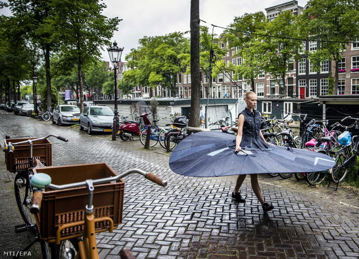 A 2020. június 12-én közreadott képen Kira Hilli, a Holland Nemzeti Balett táncosa három méter átmérőjű szoknyát mutat be egy amszterdami utcán június 4-én. A farmer anyagból készült tütüt a koronavírus-járvány miatt szükséges biztonsági távolságtartás céljából készítették.