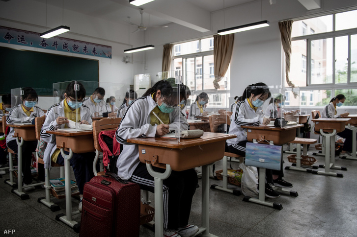 Végzős diákok plasztik elválasztófalak mögött tanulnak az iskolapadban a kínai Vuhan egyik középiskolájában 2020. május 6-án.