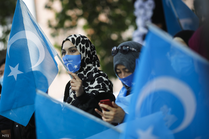 A Németországban élő ujgur közösség tagjai és szimpatizánsaik kelet-turkesztáni zászlókat lengetve tiltakoznak Vang Ji kinai külügyminiszter látogatása és a Hszincsiang-Ujgur Autonóm Területen élő ujgur nemzetiség emberi jogainak megsértése ellen Berlinben 2020. szeptember 1-jén.