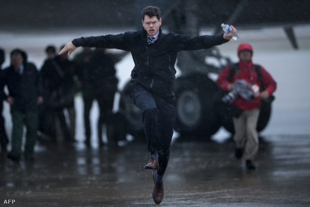 Egy riporter szalad az esőben a repülőtéren, Barack Obama  gépéhez
