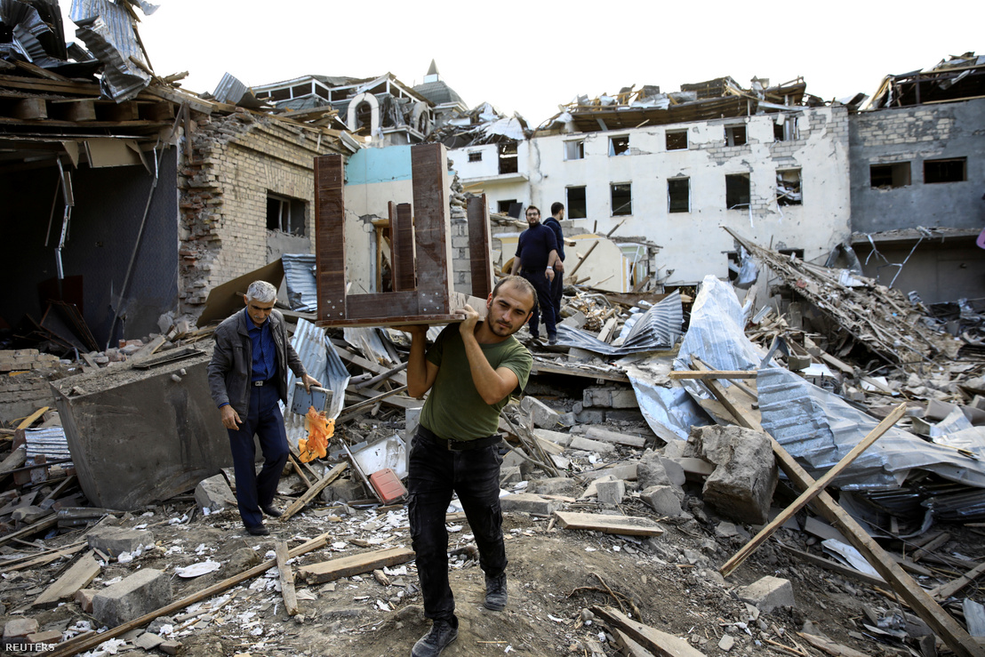 Rakétatámadás után összeomlott épület romjaiból cipel egy férfi egy asztalt a Hegyi-Karabahban, Gandzsa városában 2020. október 11-én